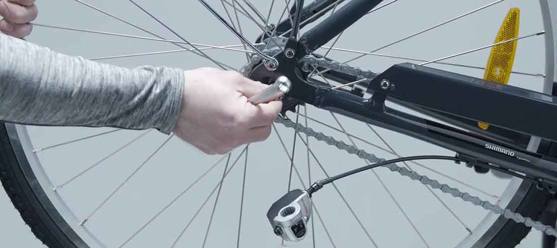 Close-up of a hand disassembling a bicycle wheel.