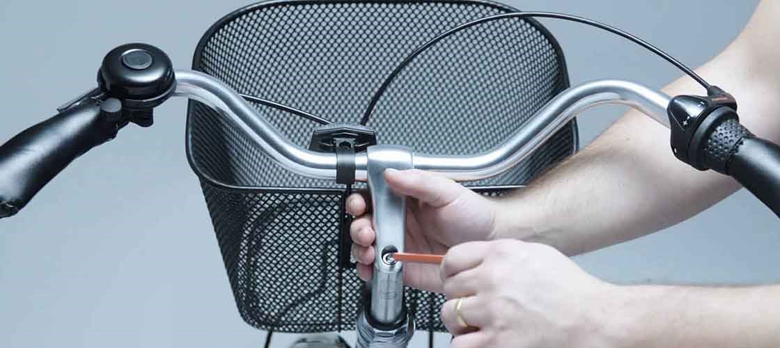 Close-up of a hand adjusting a bicycle handlebar.