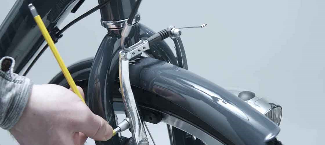 Close-up of a hand adjusting a bicycle's V-brakes.